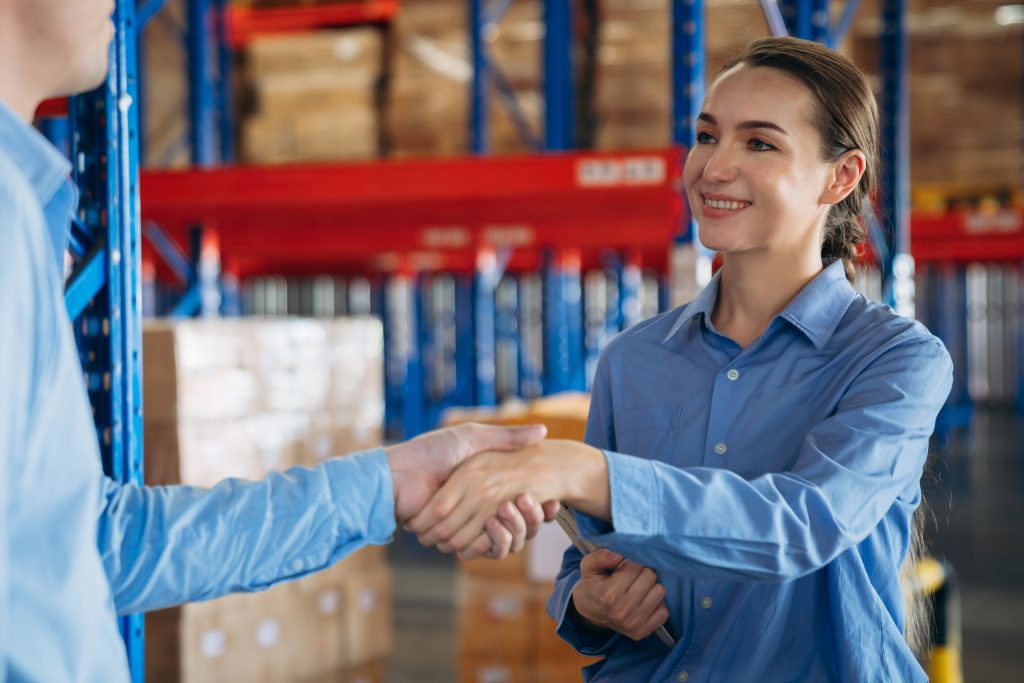 Warehouse worker stack hand and shake hands to show success in the warehouse. Worker industry join hand for collaboration.