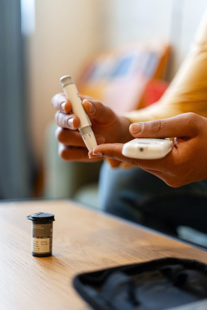 Person performing a self-test of blood glucose levels using medical devices at home